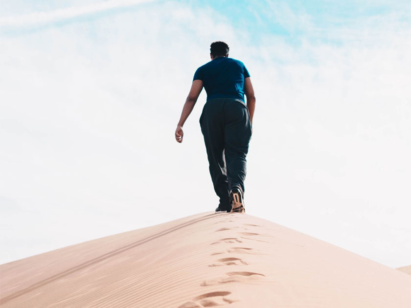 Man Walking Up Sand Hill